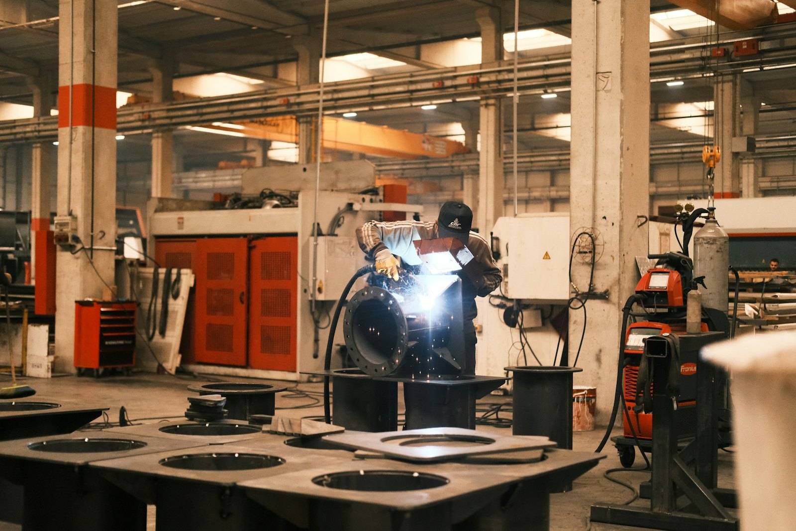 Fabrication workshop floor with a welder at work
